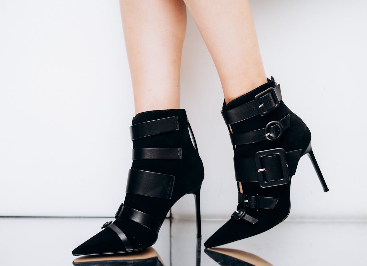 Services-01 Fashionable black high-heeled ankle boots with stylish buckle straps showcase chic footwear design.
