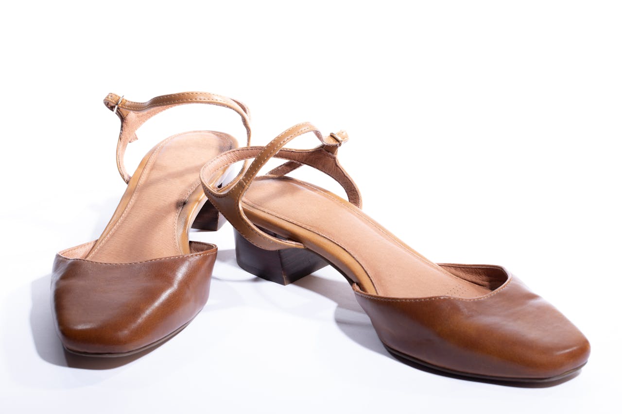 Services-02 Pair of stylish brown leather strap heeled sandals on a white background.